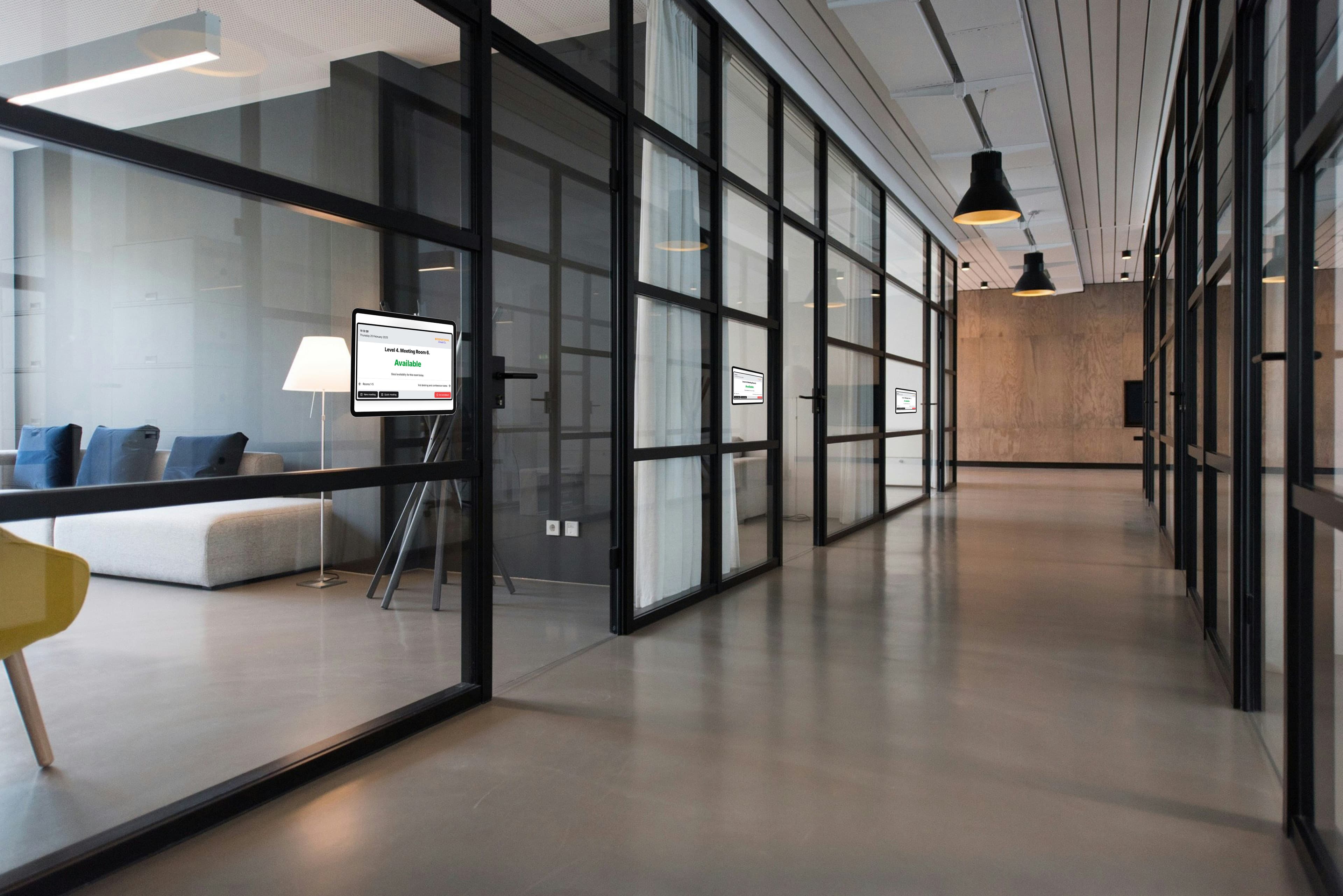 Meeting suite with glass sided meeting rooms showing tablet in use on the walls